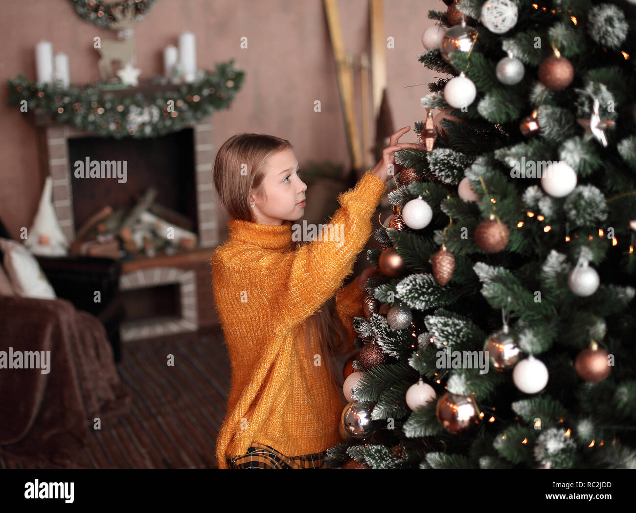 cute teen girl decorating Christmas tree in her living room Stock Photo ...