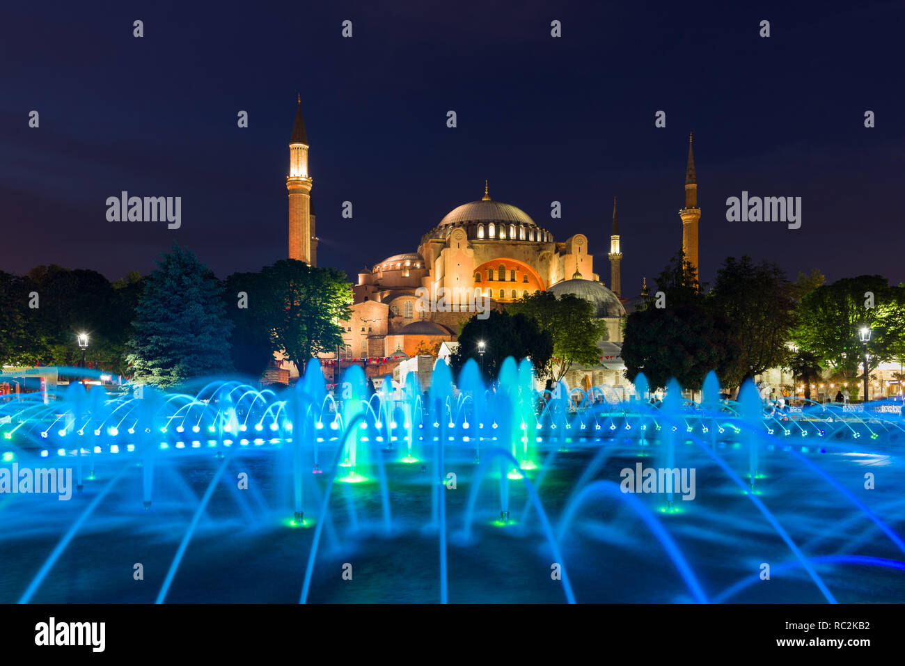 The Sultan Ahmad Maydan water fountain lit up with the Hagia Sophia museum in background at dusk, Istanbul, Turkey Stock Photo