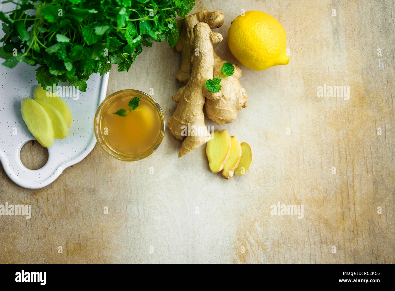 Glass with ginger detox water and ingredients near it. Wooden background. Top view. Copy space Stock Photo