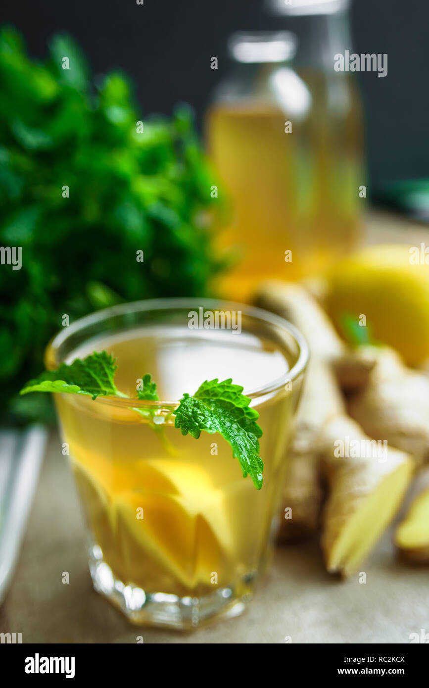 Glass with ginger detox water and ingredients near it. Wooden background. Stock Photo
