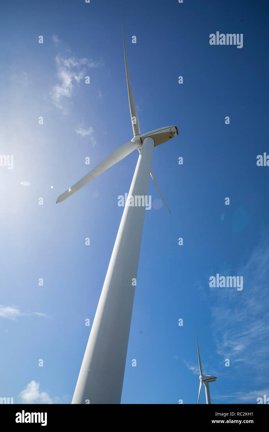 Low angle view of wind turbine against blue sky. Stock Photo