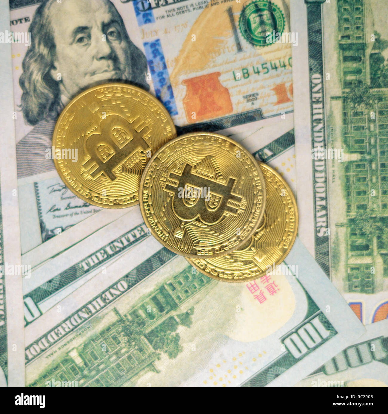 One hundred dollar bills and bitcoins Stock Photo