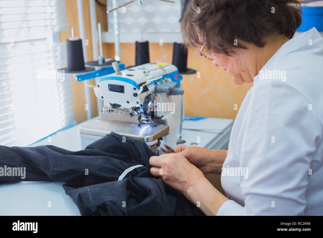 Professional tailor, fashion designer sewing clothes with sewing ...