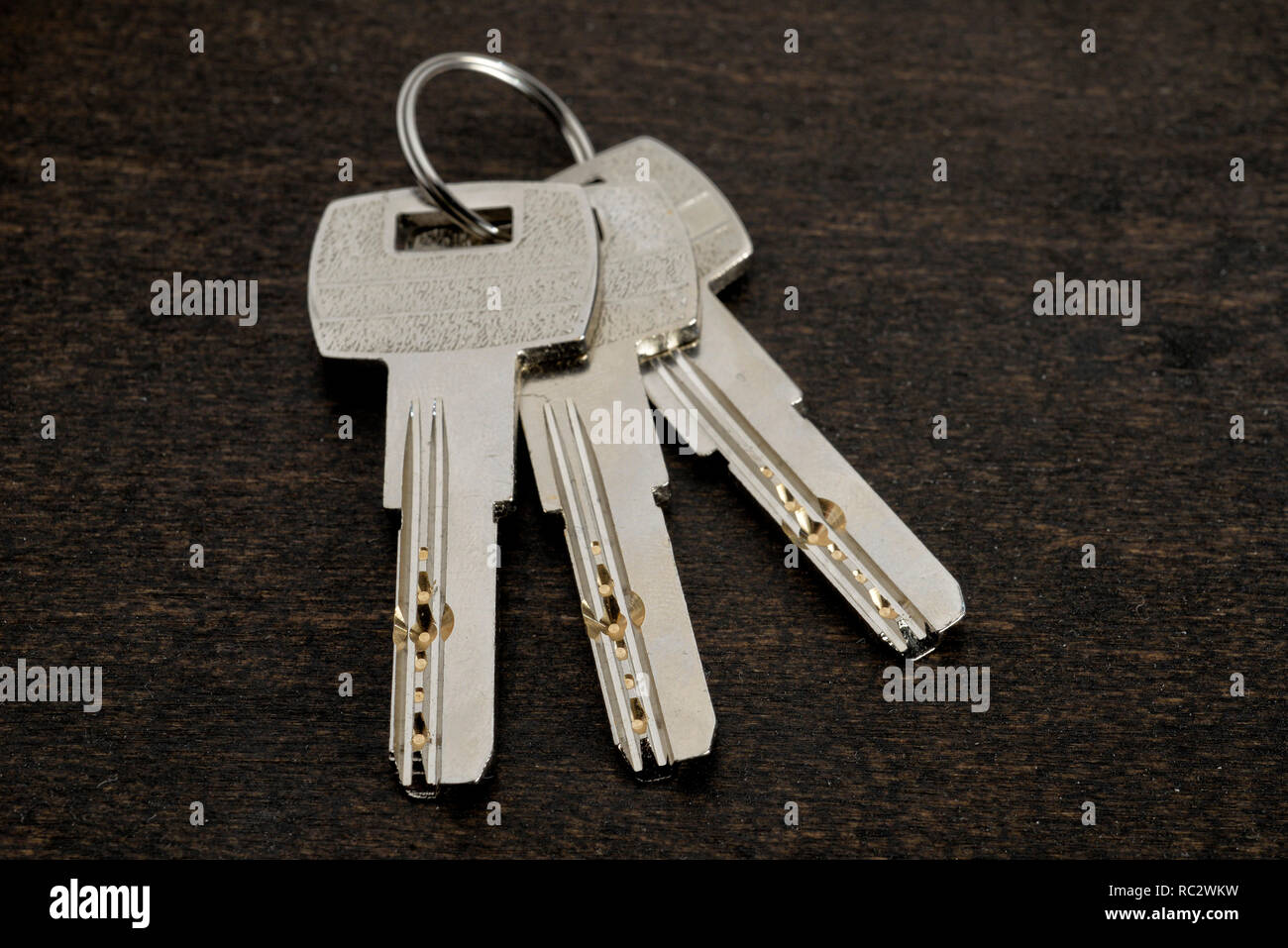 Key ring with keys over wooden background. Rent, buy home Stock Photo