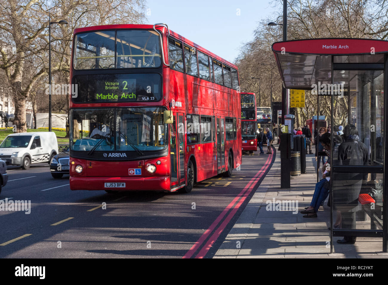 A double decker Arriva London bus, pulling away from a bus stop on a busy road, Marble Arch, London, England, UK Stock Photo