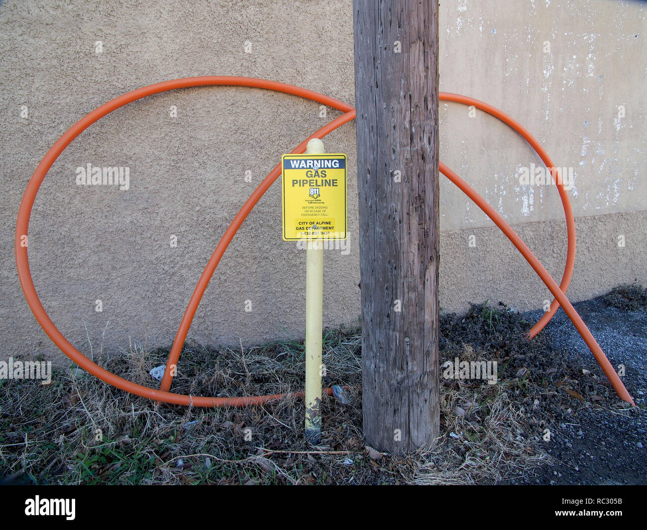 Warning about buried gas line next to an above ground electric wire conduit Stock Photo