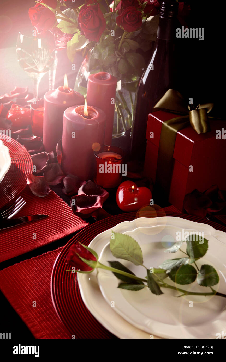 Romantic Valentine's Day Table Setting for two with red roses, gift and ...