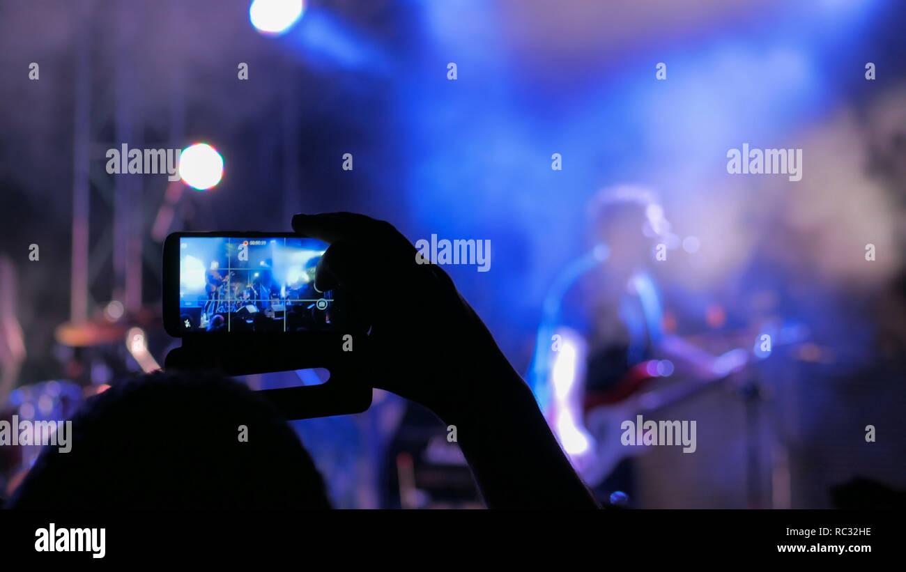 Unrecognizable hand silhouette taking photo or recording video of live  music concert with smartphone. Photography, entertainment and technology  concept Stock Photo - Alamy