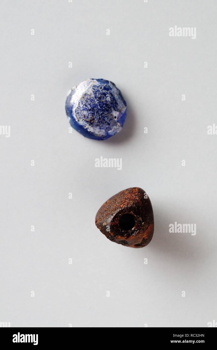Beads of vitreous paste. Blue ; Diameter 0.8 cm Thickness 0.3 cm  Red ; Diameter 0, 8cm Width 0.7 cm -  Medieval period from the archaeological site of ' La Magistral ' in Alcala de Henares - ' Burgo de Santiuste Museum ' (Madrid). SPAIN. Stock Photo