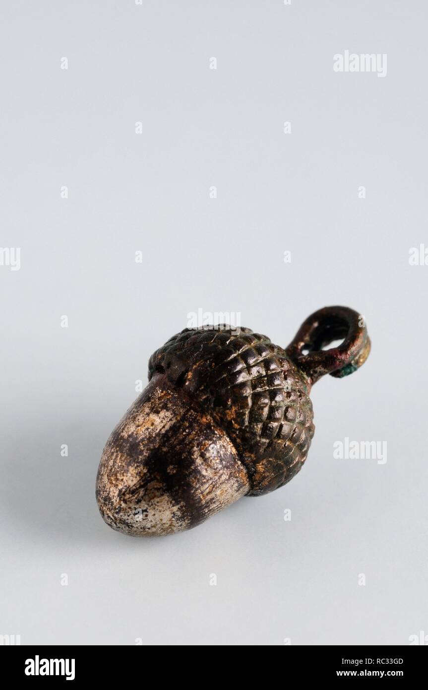Small bronze pendant in the form of acorns linked to a small washer . 1.7 cm x 0.9 cm. - Medieval period from the archaeological site of ' La Magistral ' in Alcala de Henares - ' Burgo de Santiuste Museum ' (Madrid). SPAIN. Stock Photo