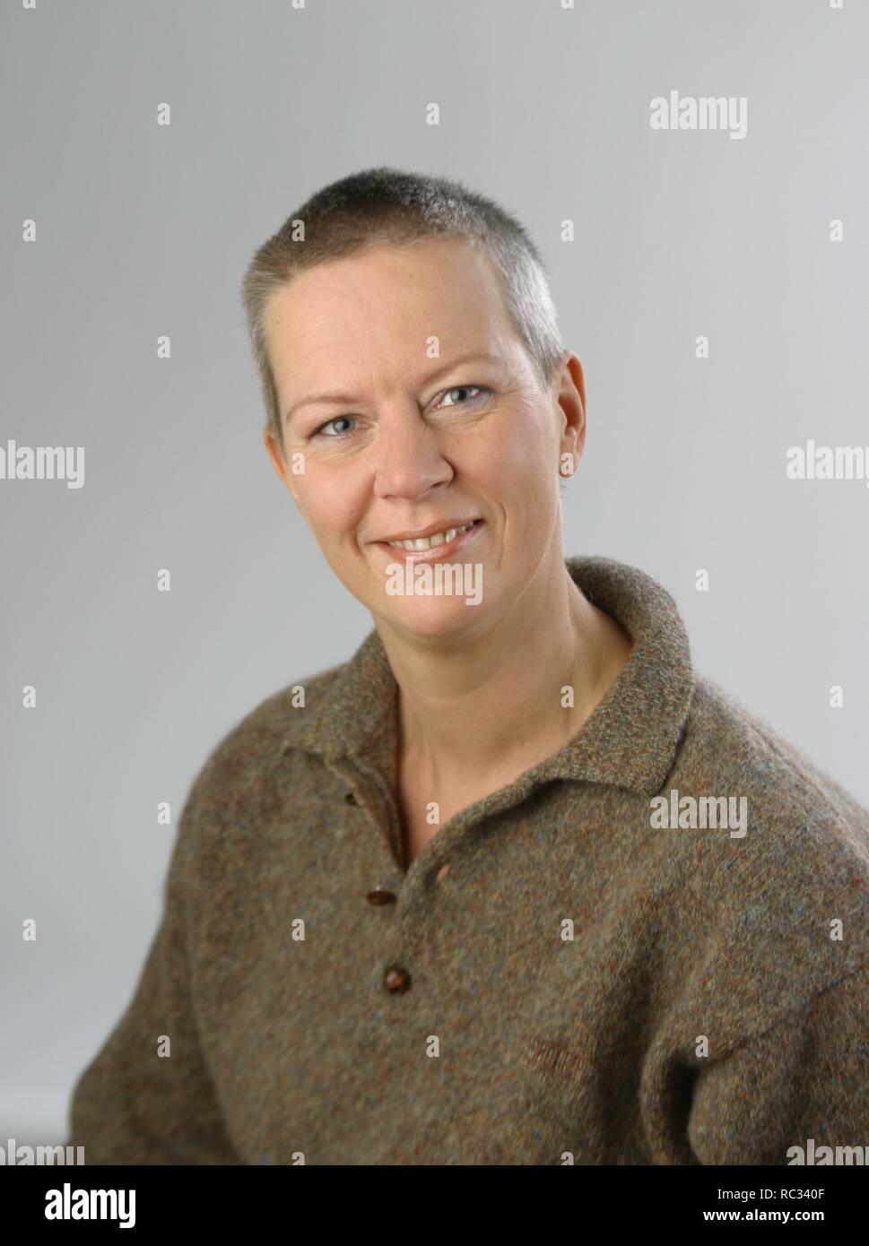 Adult womam, brown jumper, short hair, over 40; happy look at camera Stock Photo