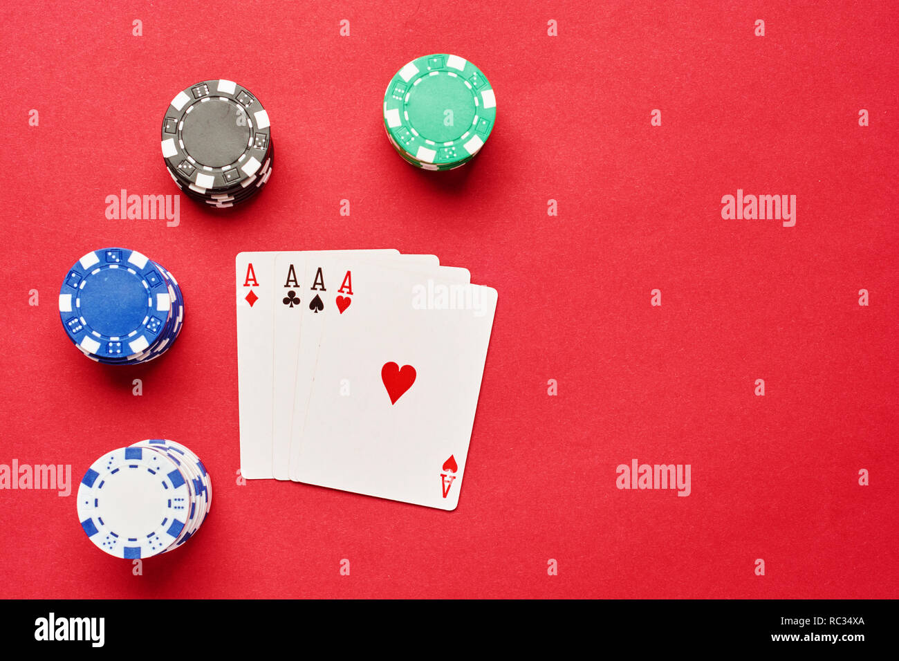 Flat lay of poker card pair of ACEs with poker chips on red paper background with copy space. Casino concept background . Stock Photo