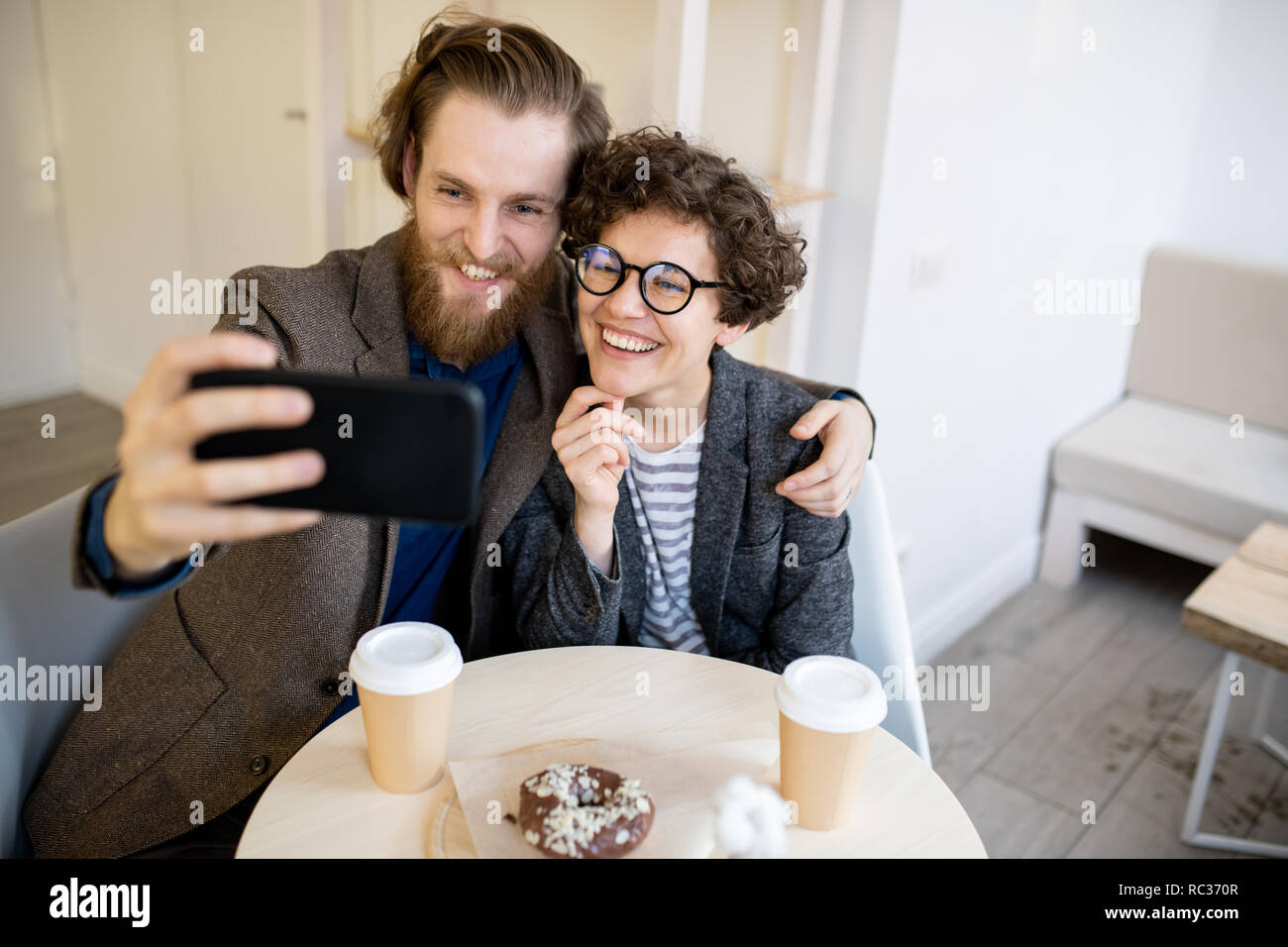 Happy hipster couple taking selfie in cafe Stock Photo