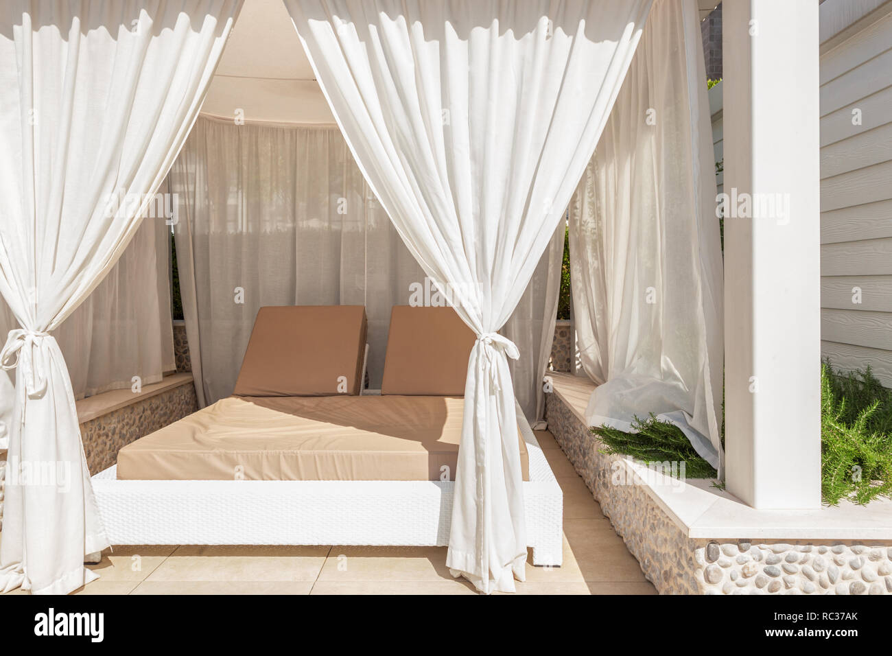 Sunbed lounge with curtain for luxury summer relaxation concept Stock Photo