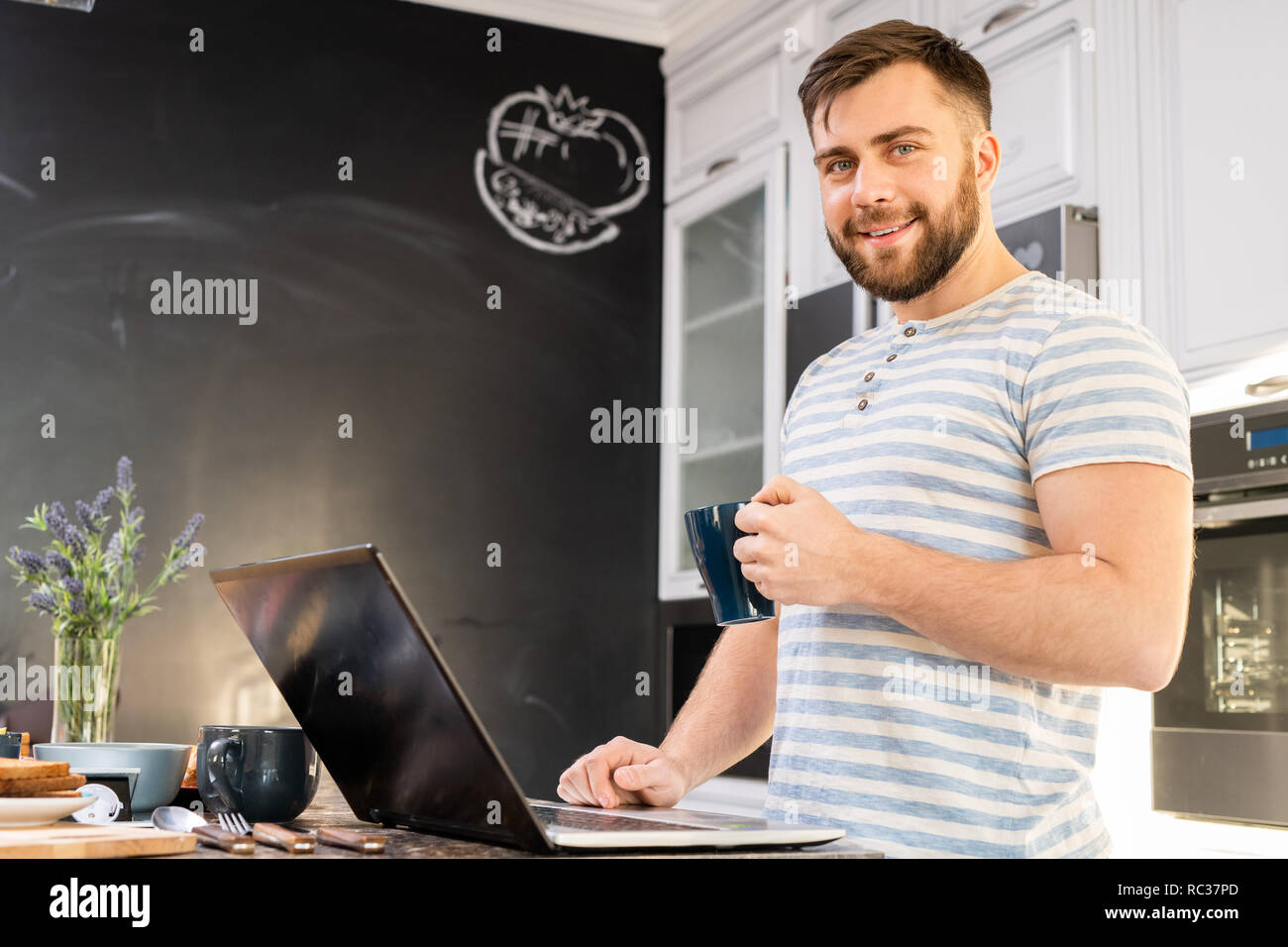 Young Man Using Laptop at Breakfast Stock Photo