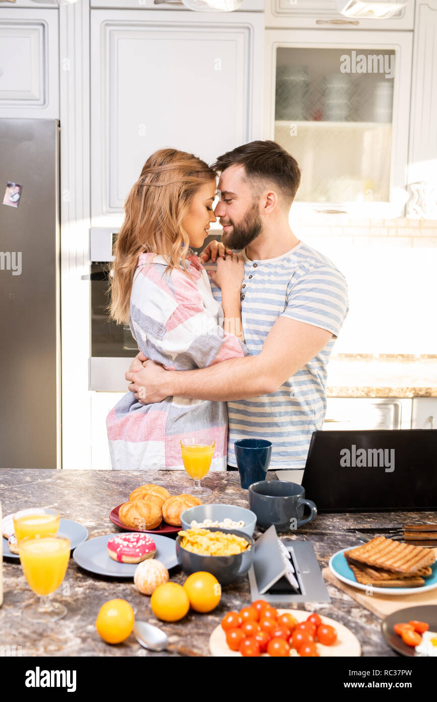 Loving Couple Embracing in Kitchen Stock Photo