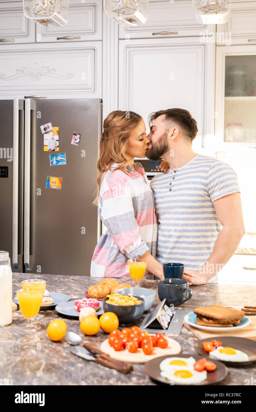 Loving Couple Kissing in Kitchen Stock Photo