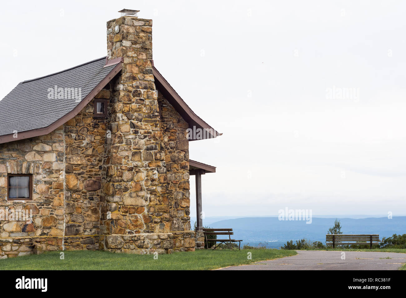 Stone building with chimney in public park with benches and a view. Stock Photo