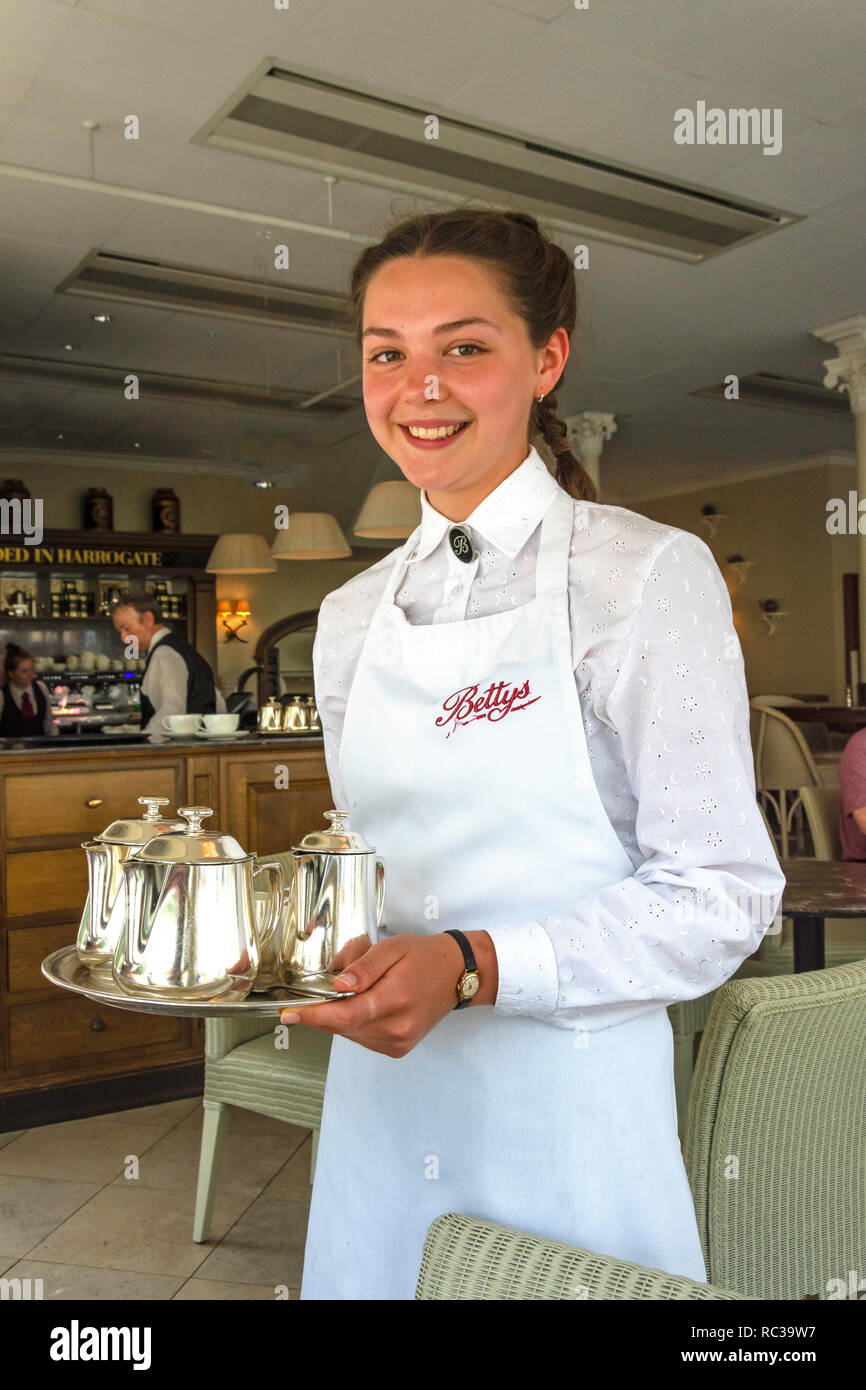 Young waitress at Betty's Cafe Tea Rooms, Parliament Street, Montpellier Quarter, Harrogate, North Yorkshire, England, United Kingdom Stock Photo