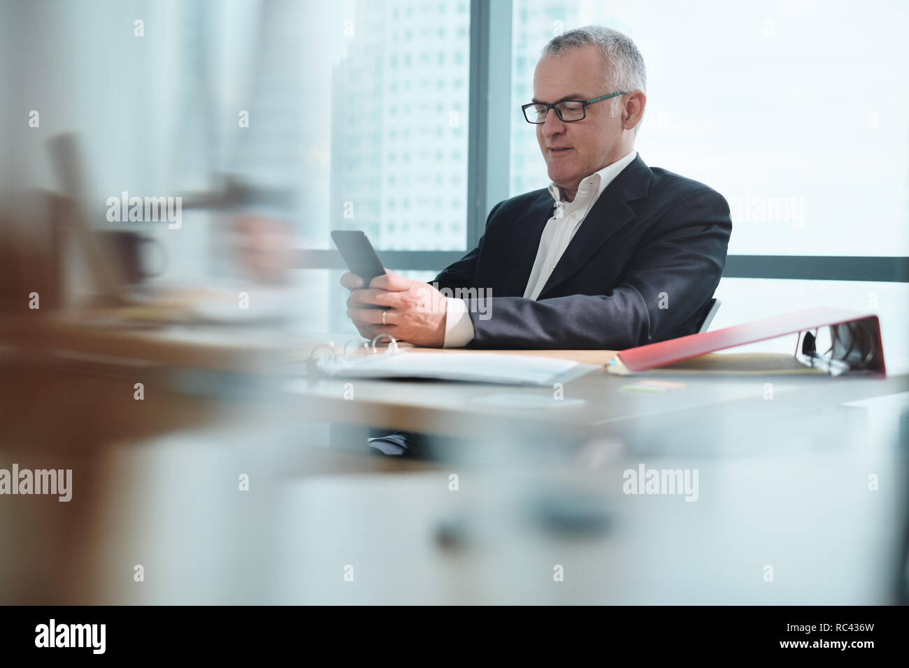 Business Man In Office Using Social Media During Working Hours Stock Photo