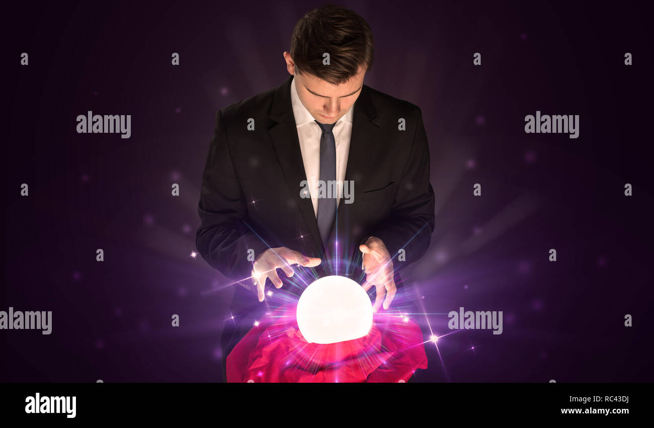 Young businessman sitting with crystal ball in action Stock Photo - Alamy