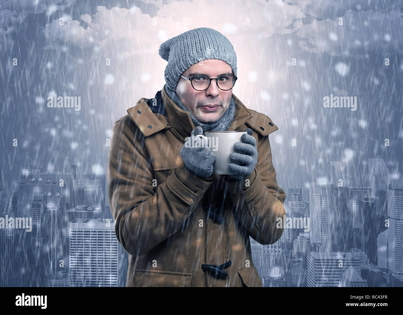 Young man freezing in warm clothing with city concept  Stock Photo