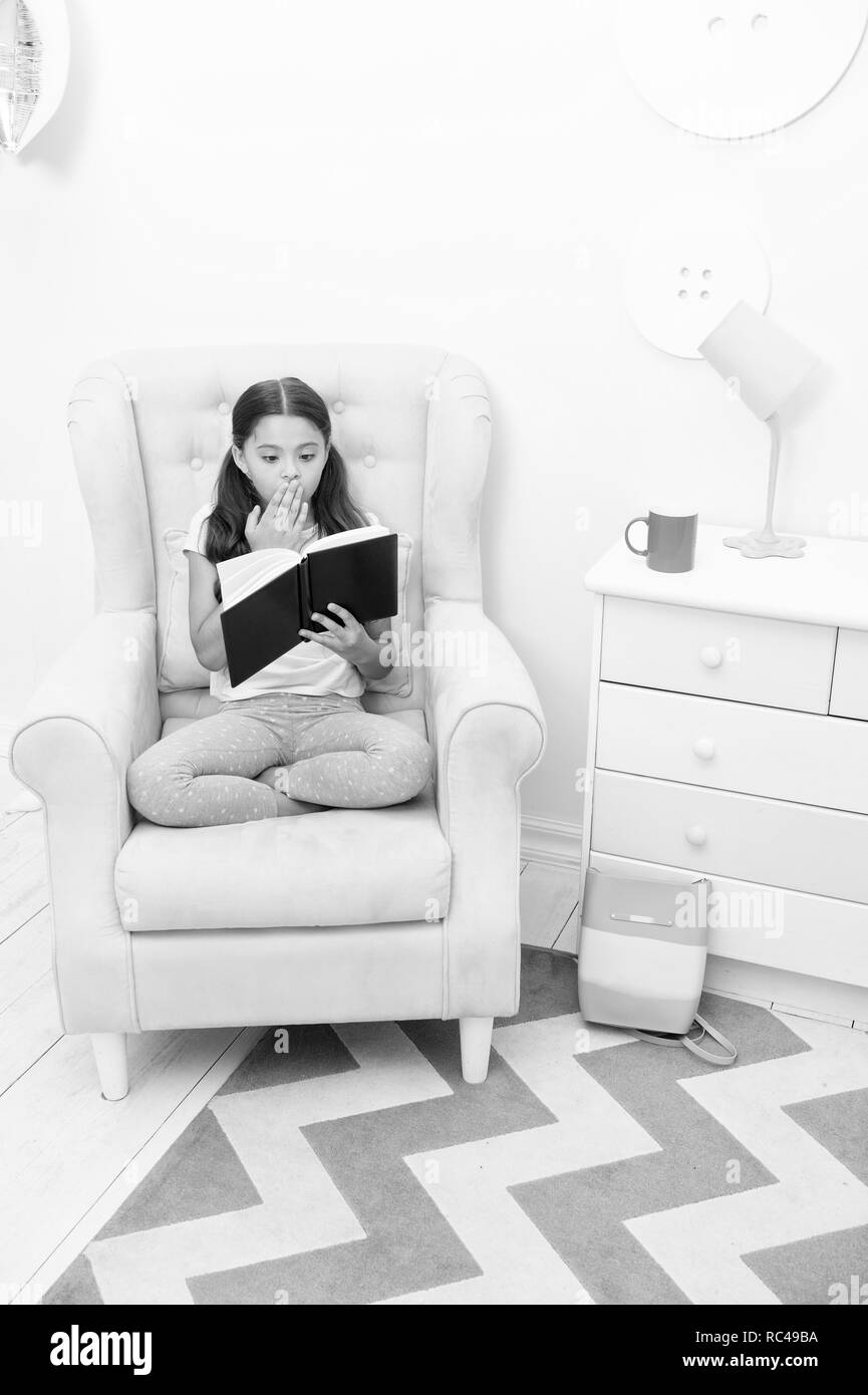 Story concept. Little girl read story in chair. Child reading story book. Story time. Once upon