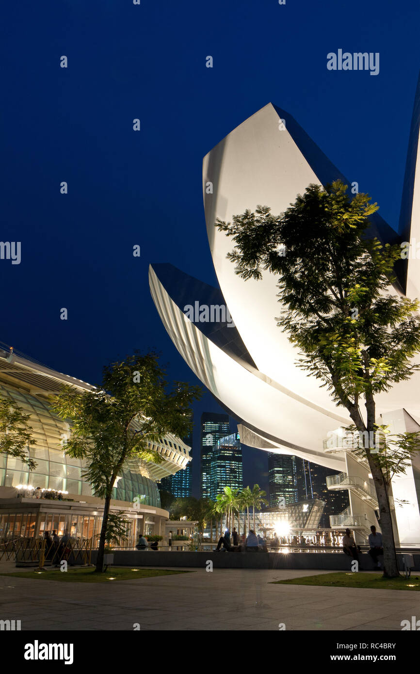 Marina Bay Sands shopping mall and few people sitting in front of the lit  ArtScience Museum in Singapore in the evening Stock Photo - Alamy