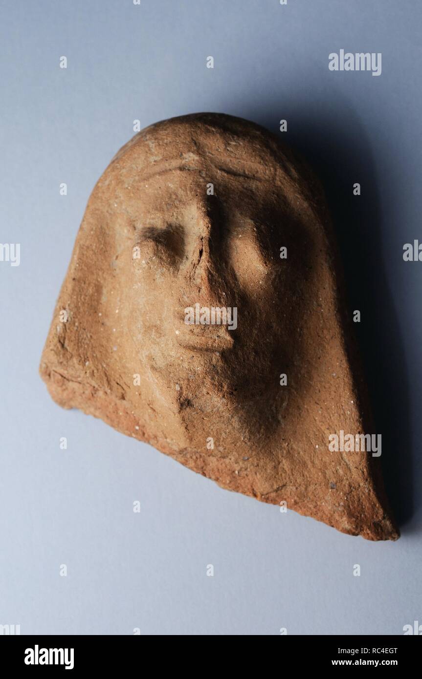 Antefixes of terracotta representing male head anthropomorphic primitive and highlighted eyes. Height 8 cm Width 6,6 cm Weight 3, 4 cm ( 1st CE ) Roman period, from the ' Basilica ' - Archaeological site of Complutum in Alcalá de Henares ( Madrid ). SPAIN. Stock Photo