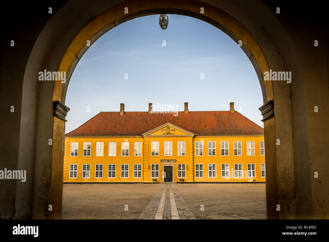 The gate to the yellow palace in Roskilde, and  the arch and a blue sky. Roskilde, Denmark, January 11, 2019 Stock Photo