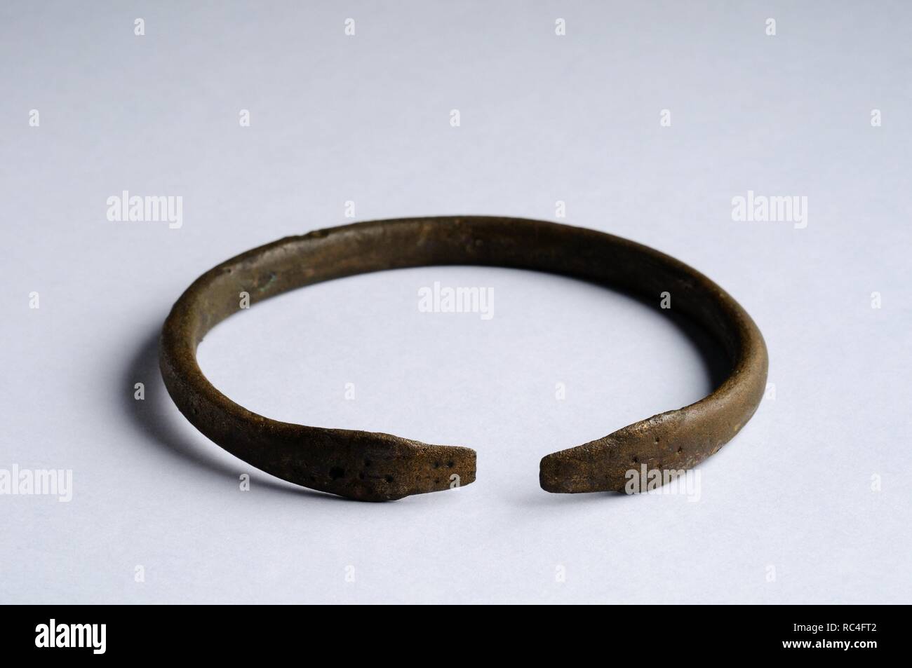 Bronze bracelet , represented in the end of two snakes heads facing and dotted decoration.  Diameter 6, 7 cm Thickness 0.3 cm ( 5 th - 8 th CE )  Visigoth period, from the ' Calle Victoria '- Archaeological site of Complutum in Alcalá de Henares ( Madrid ). SPAIN. Stock Photo
