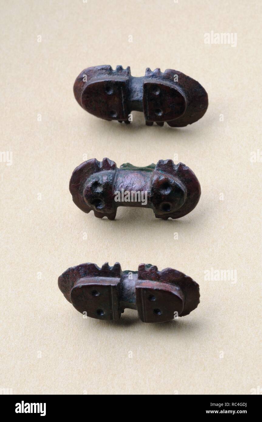 Three bronze buttons of similar proportions with incised decoration ...
