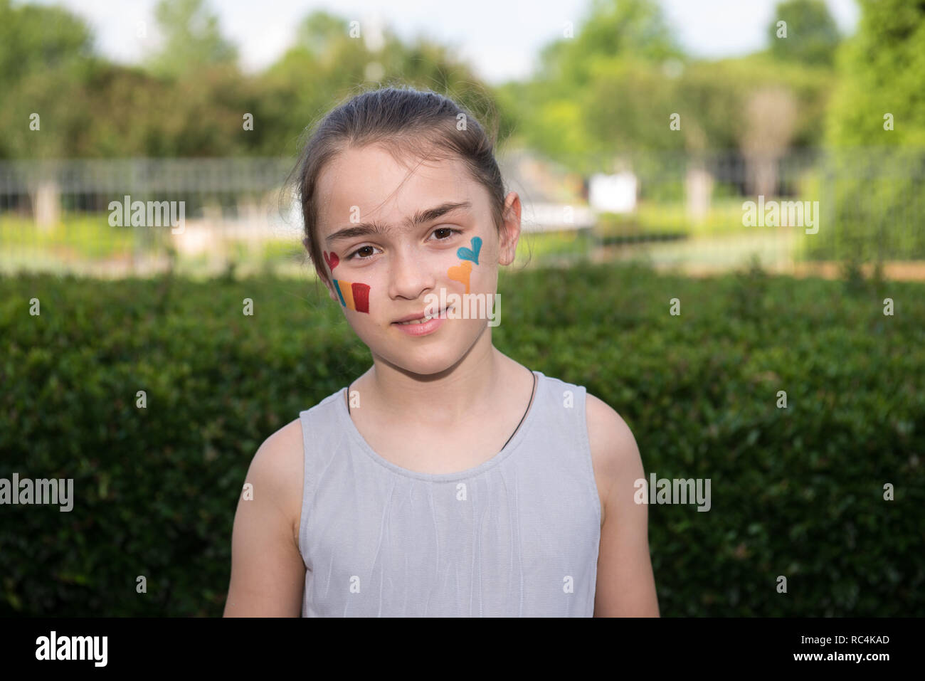 Girl with face painting symbolizing love of or Romania or Romanian flag. Stock Photo
