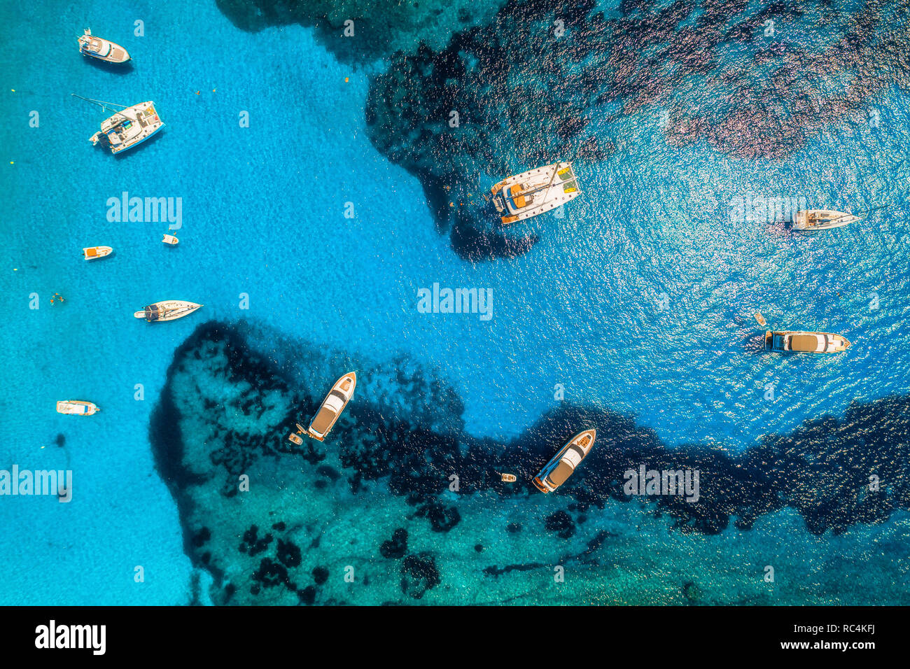 Aerial view of boats and luxury yachts in transparent blue sea at sunny ...