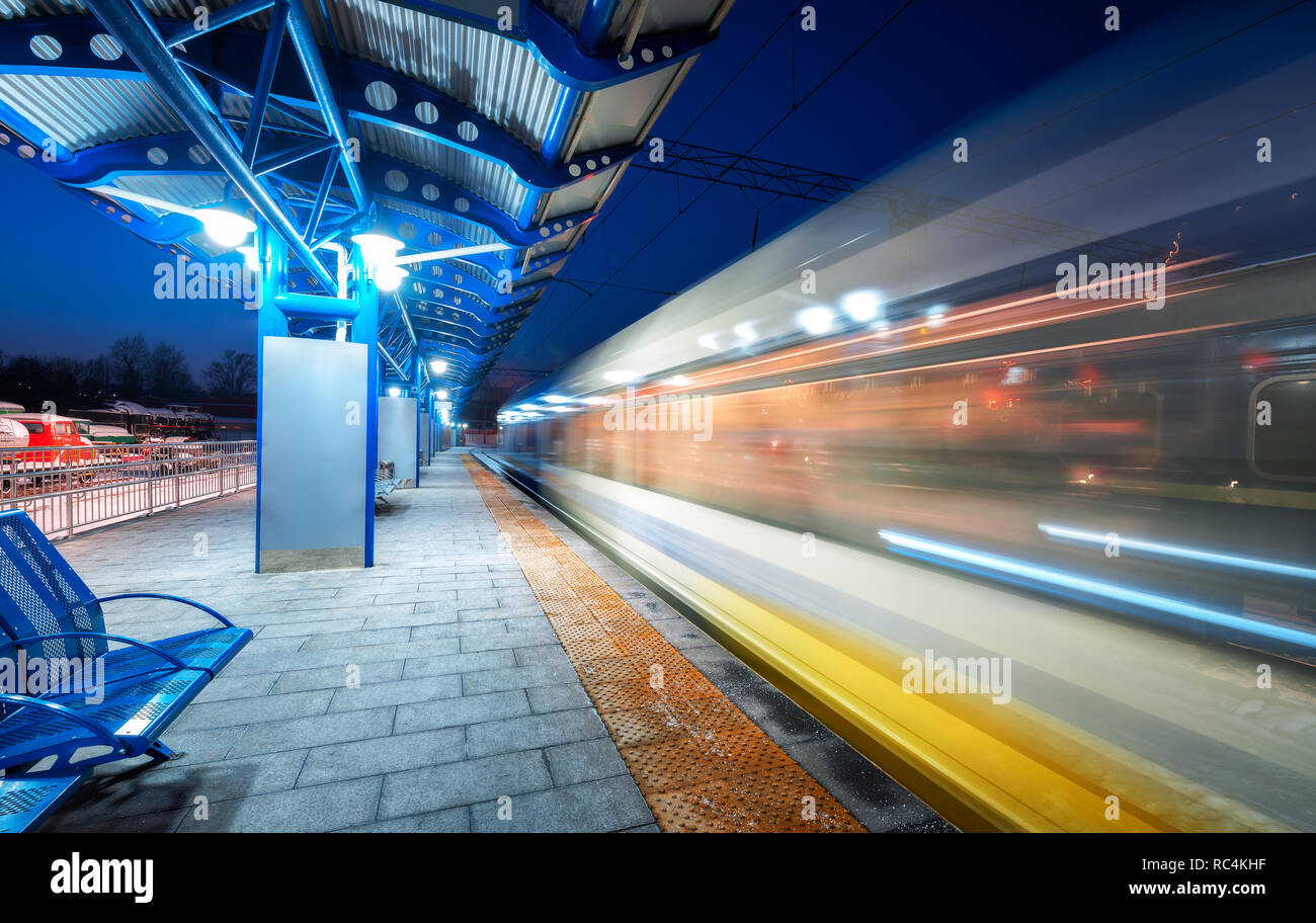 Blurred high speed train on the railway station at night in Europe ...