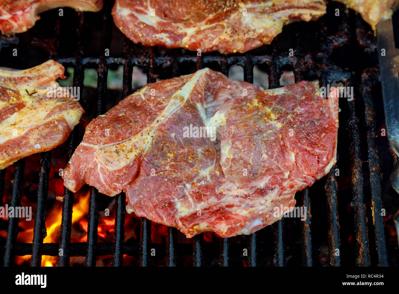 Beef steak on the grill grate, flames barbecue and grill, delicious food. Stock Photo