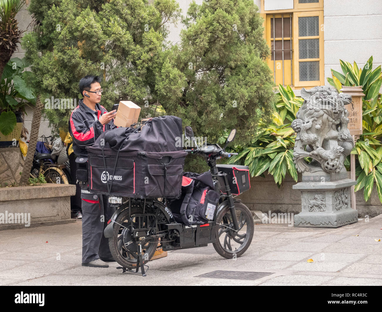 SF urgent courier delivery man delivering parcels in Xiamen Stock Photo