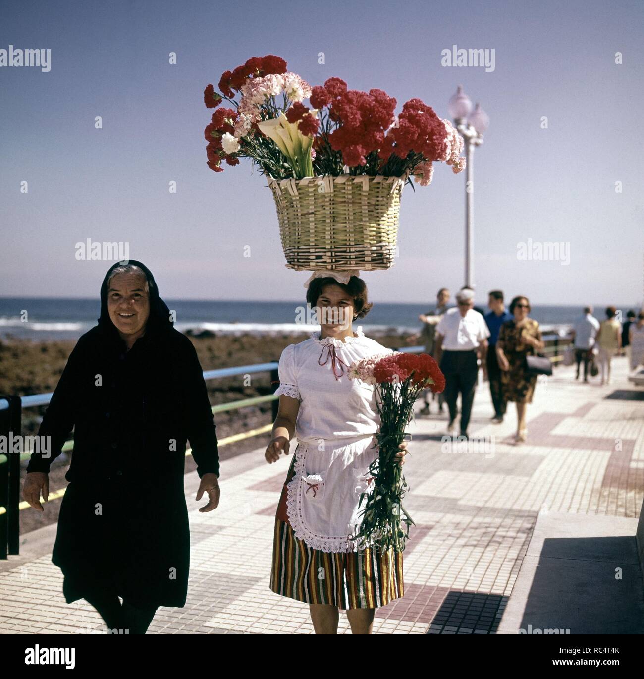 Florista Con Cesto De Claveles En La Cabeza En El Paseo Maritimo Del Puerto De La Cruz Anos 60 Siglo Xx Location Exterior Teneriffa Spain Stock Photo Alamy