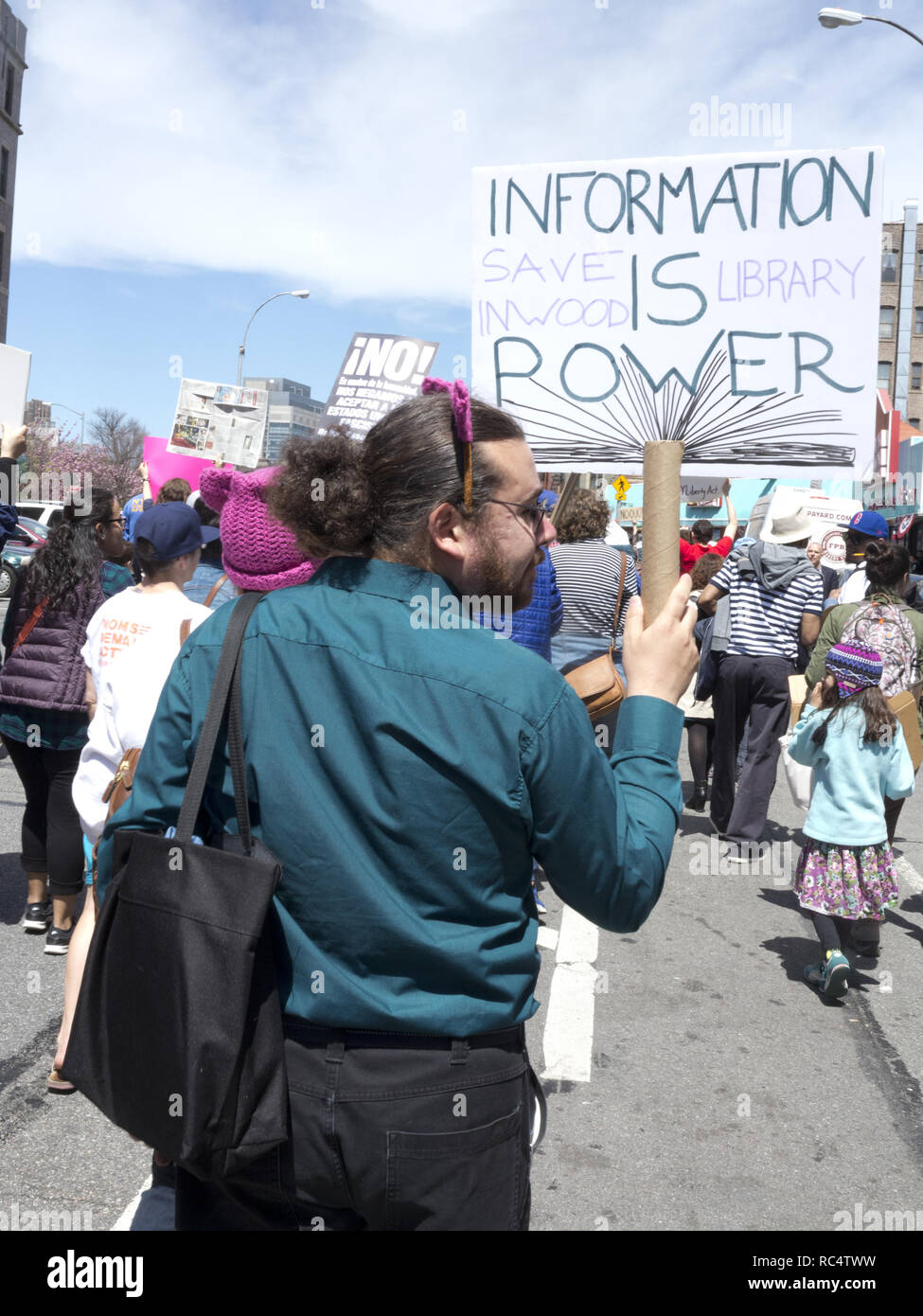 Hundreds of protesters gathered in Harlem to rally and march in The Uptown March for Immigrants, 2017. Man holds 'Save Inwood libraries' sign. Stock Photo