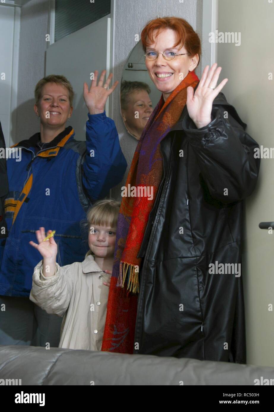 Two women and a little girl take leave and wave and look happy at the camera Stock Photo