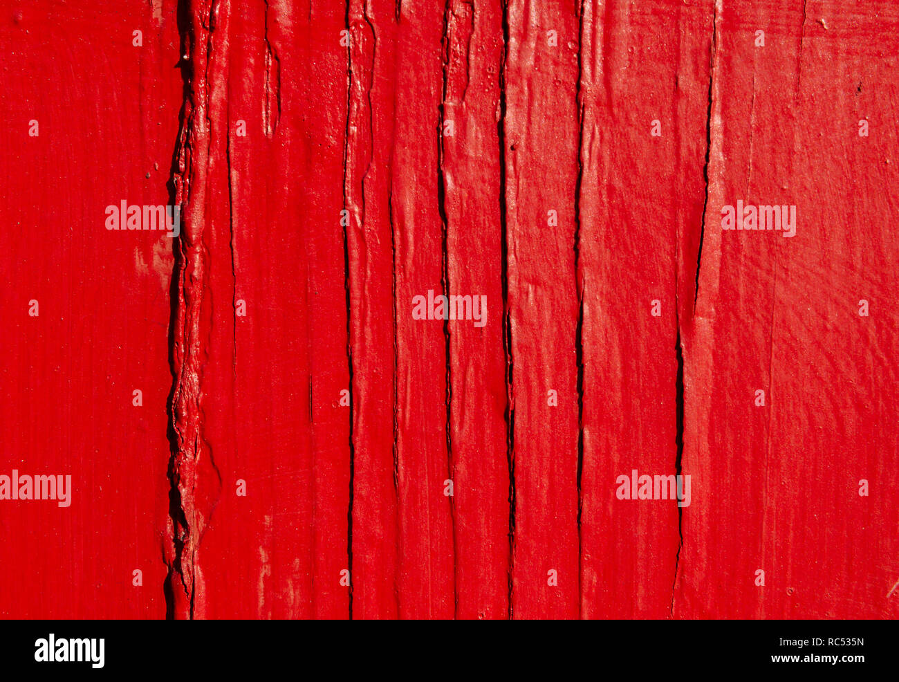 Rough, weathered wood is painted red with cracked, peeling paint, Dec. 23, 2018, in Mobile, Alabama. Stock Photo