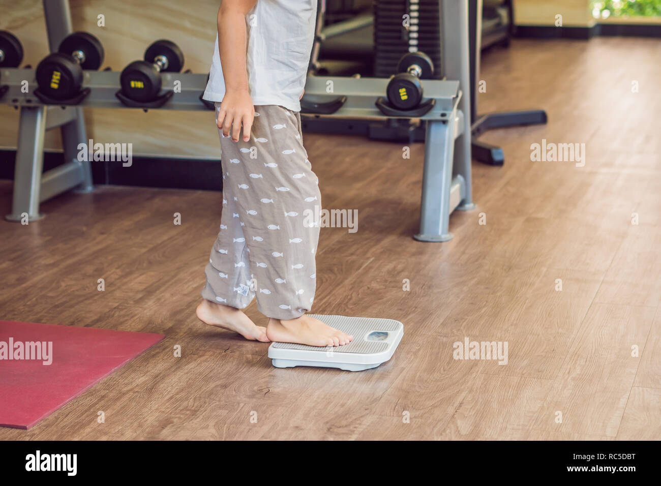 The boy stands on the scales to find out his weight Stock Photo Alamy