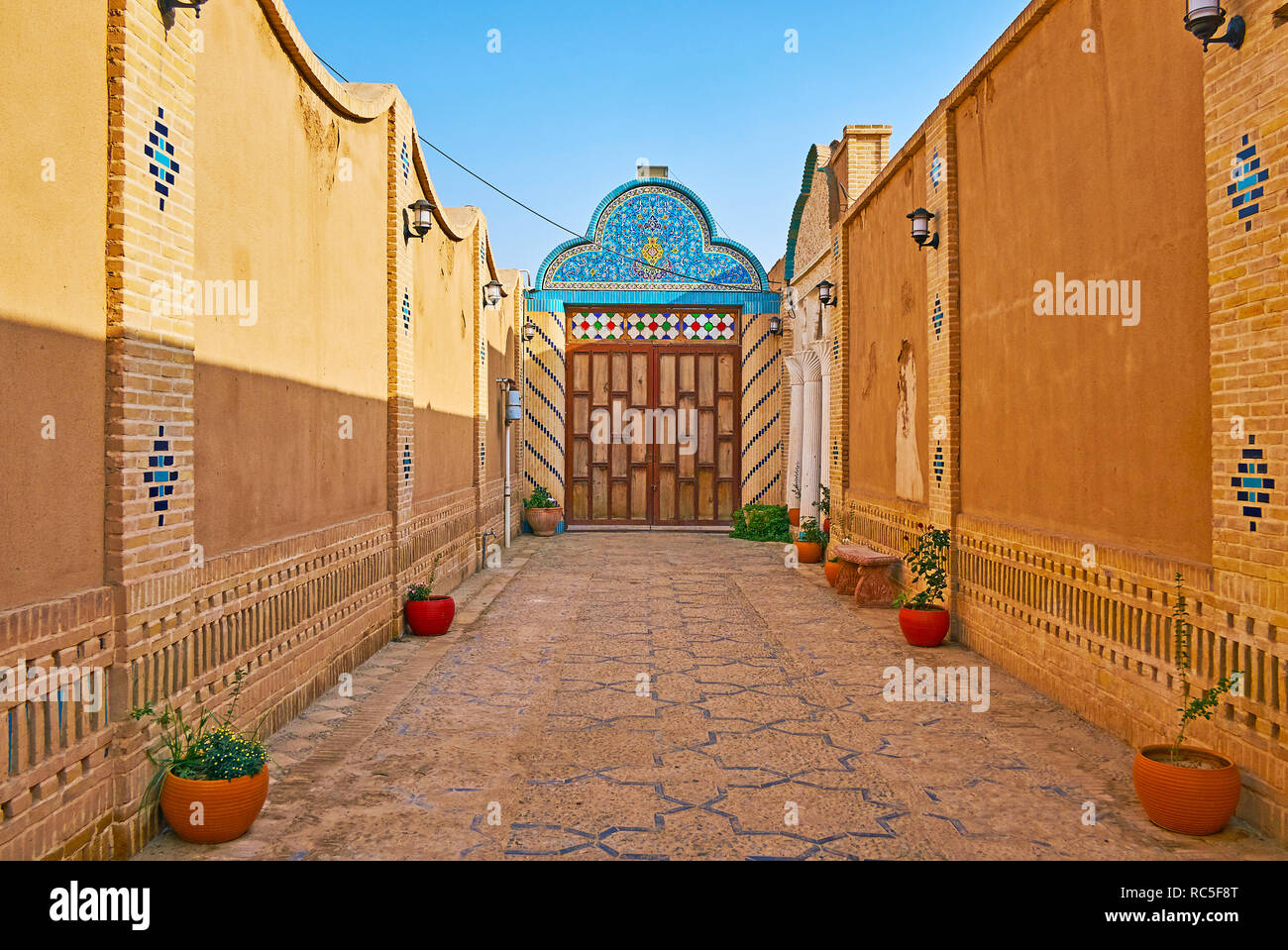 YAZD, IRAN, OCTOBER 18, 2017: The medieval edifice of Yazd Bar Association boasts traditional narrow courtyard, decorated with tiled patterns, on Octo Stock Photo