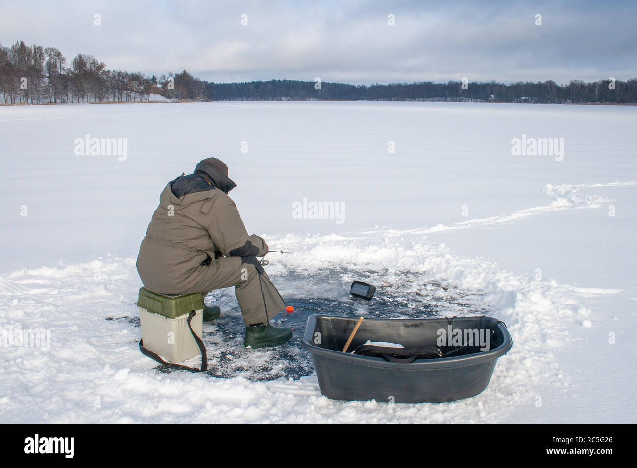 Fishing on a frozen lake in winter, hole and equipment , sonar Stock Photo  - Alamy