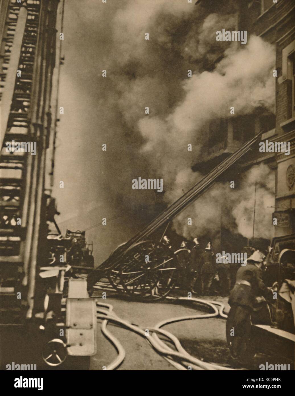 'Subduing a Conflagration in a Narrow City Street', c1935. Creator: Unknown. Stock Photo