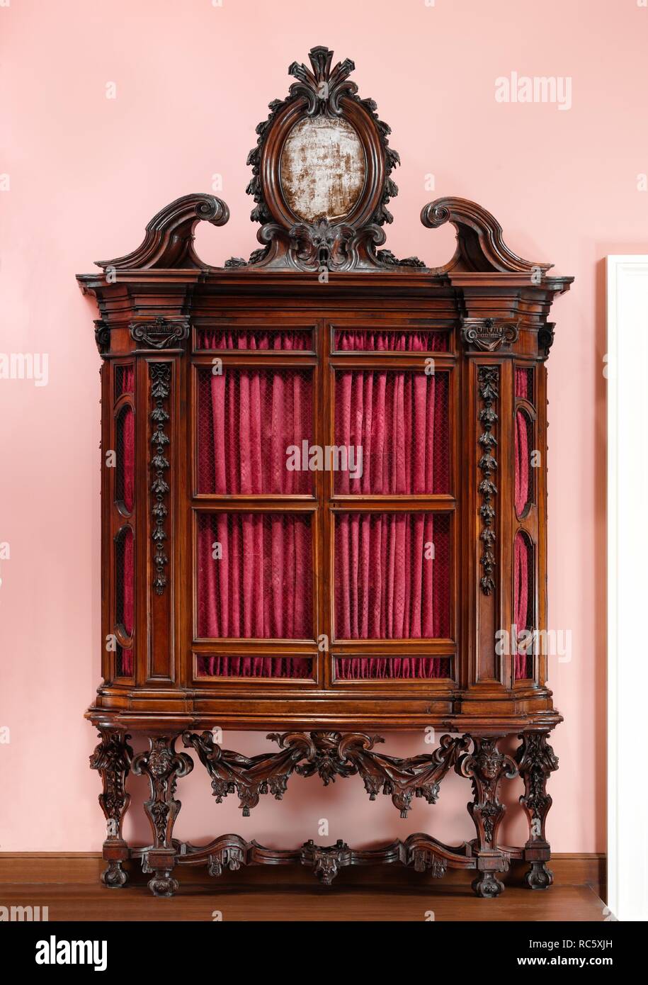 Bookcase (one of a pair). Culture: Italian, Rome. Designer: Design attributed to the architect Niccolo Michetti (Italian, died 1759). Dimensions: Overall: 159 x 24 x 94 in. (403.9 x 61 x 238.8 cm). Date: ca. 1715.  During the seventeenth and eighteenth centuries Rome was the capital of the Papal States. All the important administrative departments of the Roman Catholic Church were located within its walls. Of these, the Sacred College of Cardinals was the most significant. Only its members could vote in conclave for the next Vicar of Christ, a new pope. To become a part of this powerful body w Stock Photo