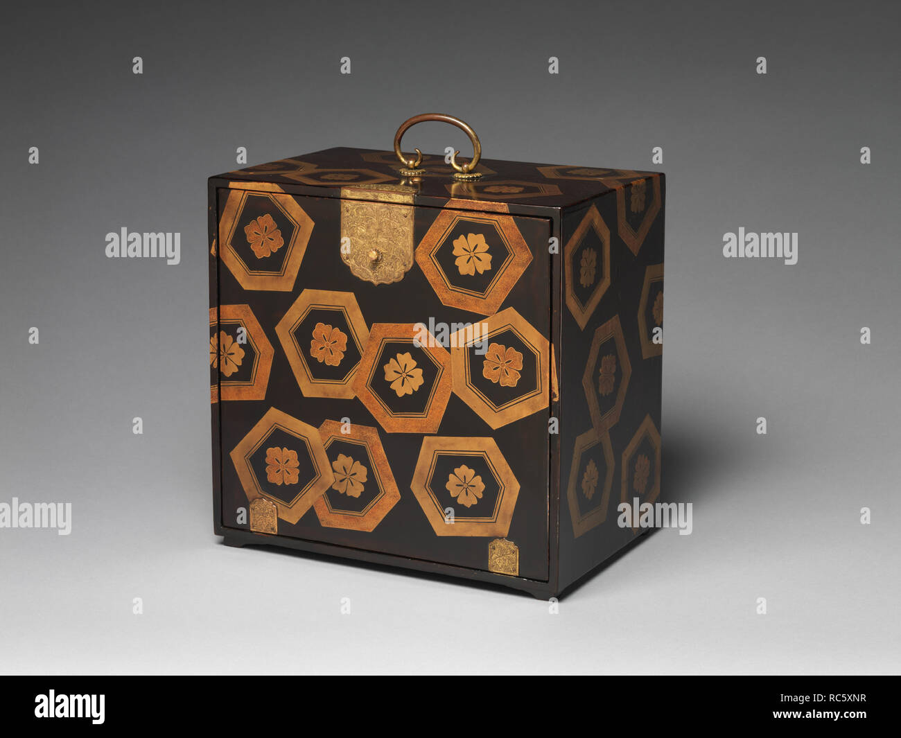 Cabinet with Design of Stylized Tortoiseshell Patterns. Culture: Japan. Dimensions: L.14 1/8 in. (35.9 cm); W. 9 1/2 in. (24.1 cm); H.14 1/4 in. (36.2 cm). Date: late 16th-early 17th century.  Often referred to as medicine chests, boxes such as this one, with a front cover and interior drawers, were also designed for traveling. The dramatic rendering of stylized tortoiseshells on the exterior is matched by the three wonderful cranes found on the front of the drawers. In both China and Japan, these motifs are often associated with a mythical mountain inhabited by immortals. Museum: Metropolitan Stock Photo