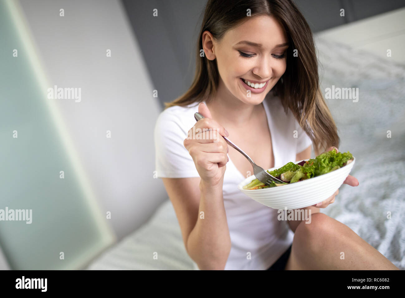 Beautiful woman eating healthy fresh organic salad Stock Photo