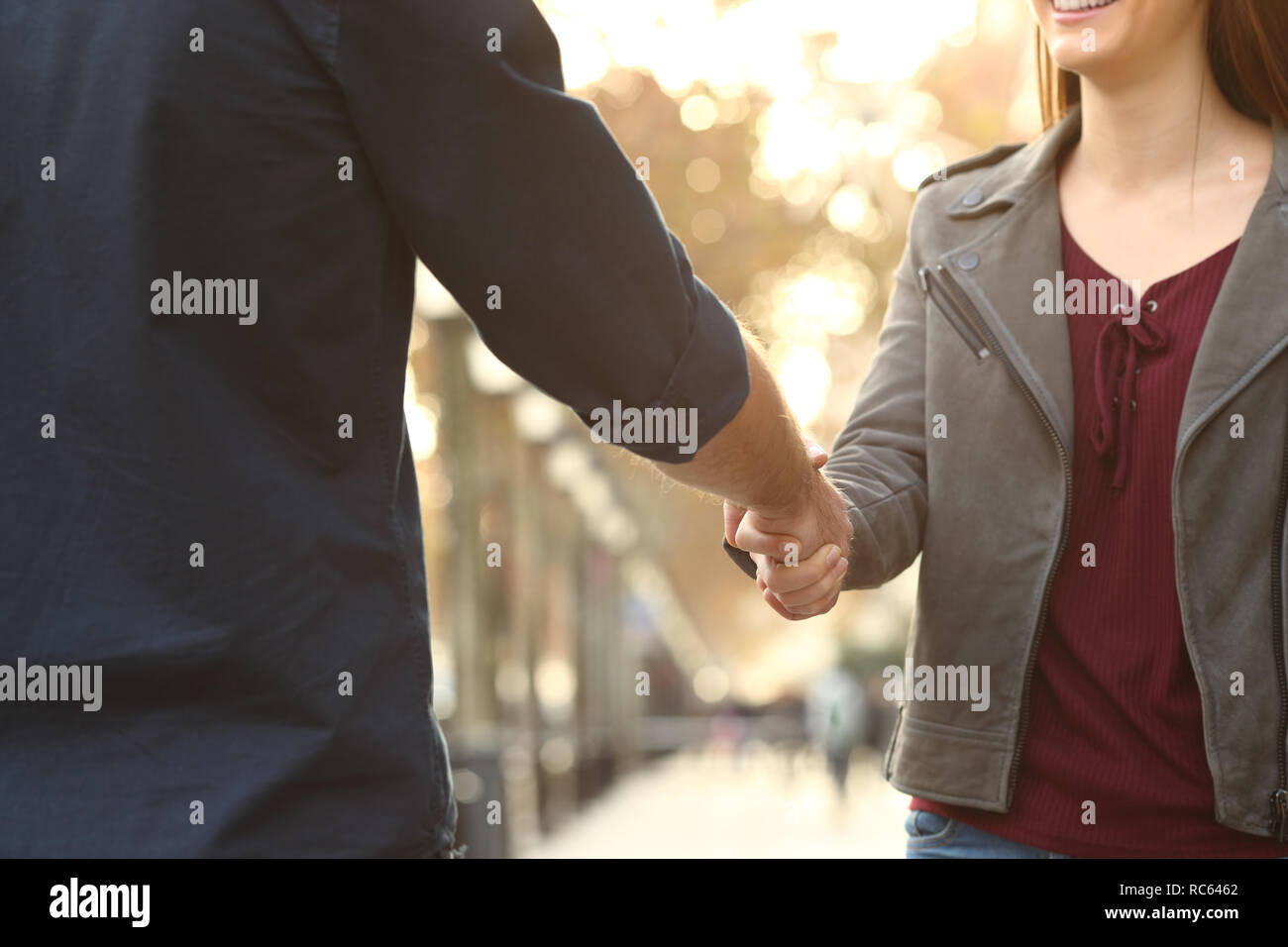 Close up of a happy woman and man hands handshking in the street Stock Photo