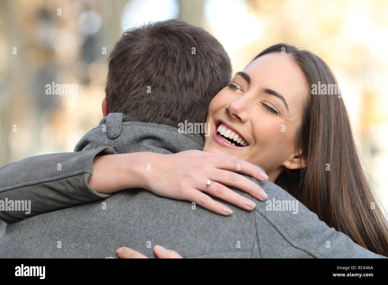 Portrait of a couple hugging after happy proposal in the street Stock Photo